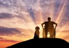 Person in wheelchair with a dog watching the sun rays